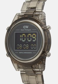 Reloj cronógrafo digital con una caja de resina gris transparente, una pantalla digital negra y una correa clara. Presenta números grandes y fáciles de leer.