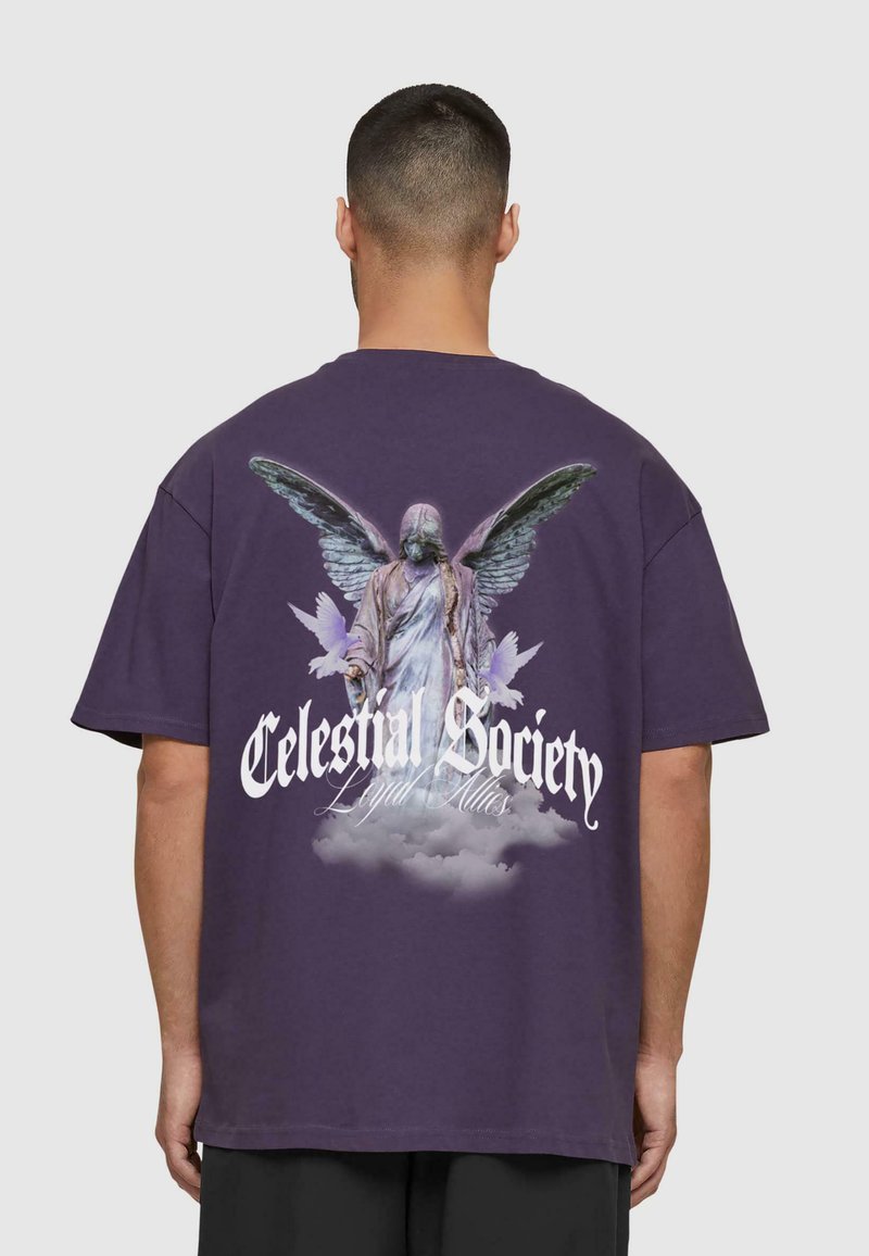 Lilla oversized t-shirt med et grafisk motiv af en vinget statue på bagsiden, med teksten "Celestial Society" i hvid.