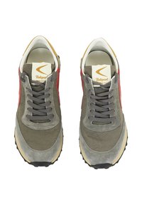 Zapatillas de lona gris y ante con detalles rojos, gruesos cordones grises, forro blanco y suela de goma negra. Presentan un logo en la lengüeta.