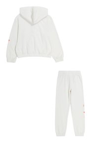 Felpa bianca con cappuccio, maniche e orlo a costine, con un logo arancione sulla manica; pantaloni joggers bianchi abbinati con vita elastica.