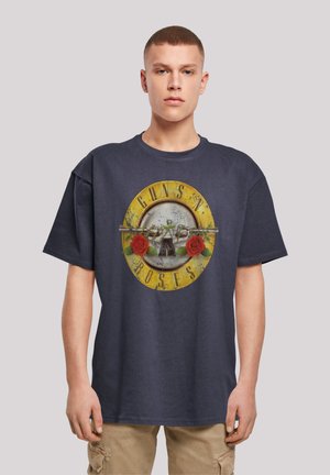 Navy cotton t-shirt featuring a round graphic design with "GUNS N' ROSES," embellishments of roses, and a textured circular background.