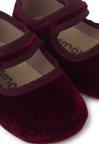 Bordeaux fluwelen babyschoenen met ronde neuzen, stoffen banden en een zachte voering. Opvallende textuur is pluche met een gladde afwerking op de zolen.
