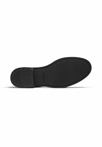 Black shoe sole featuring a textured surface, slight heel, and metal studs for traction. The shape is elongated with rounded edges.