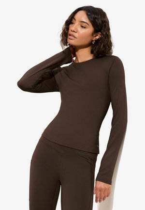 Braunes Langarmshirt aus elastischem Stoff mit Figurbetonung und Rundhalsausschnitt. Glatte Textur mit minimalen Nahtdetails.
