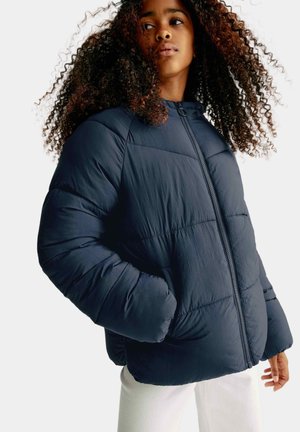 Veste matelassée marine avec fermeture éclair à l'avant, dotée d'un design matelassé, d'un col haut et de poches latérales. Matériau synthétique léger avec une finition lisse.