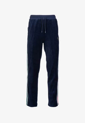 Navy blue velour joggers with elastic waistband, drawstring, and side stripes in green, white, and red. Features logo on the leg.