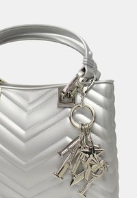 Borsa a tracolla argento imbottita con motivo a chevron, dotata di un portachiavi removibile con metalleria argentata e finitura testurizzata.