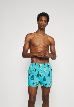 Schwimmshorts in leuchtendem Türkis mit einem lustigen Avocado- und Comicfiguren-Druck, einem elastischen Bund und einem Etikett auf der Vorderseite.