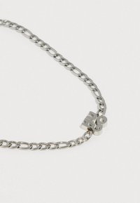 Colier din argint cu zale rotunde, având un mic accent metalic cu numerele „20” pe o secțiune. Textură netedă pe întreaga suprafață.