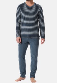 Chemise à manches longues bleu marine avec un col en V et des rayures blanches ; associée à un pantalon doux bleu foncé. Les deux sont fabriqués dans un tissu confortable pour le vêtement de détente.