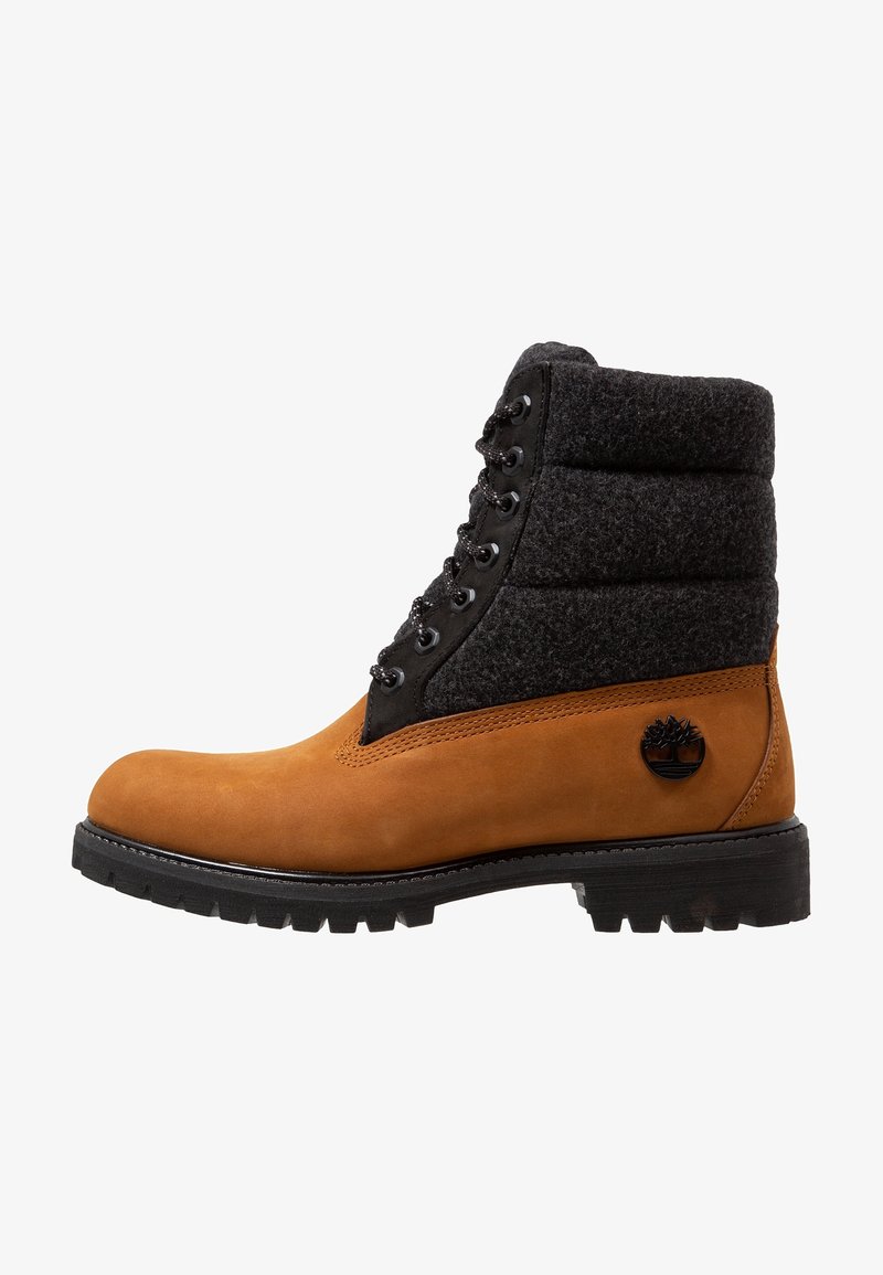 Bottine en daim beige et feutre noir avec design à lacets, semelle en caoutchouc et accent de logo. Dispose d'un col rembourré pour un confort accru.