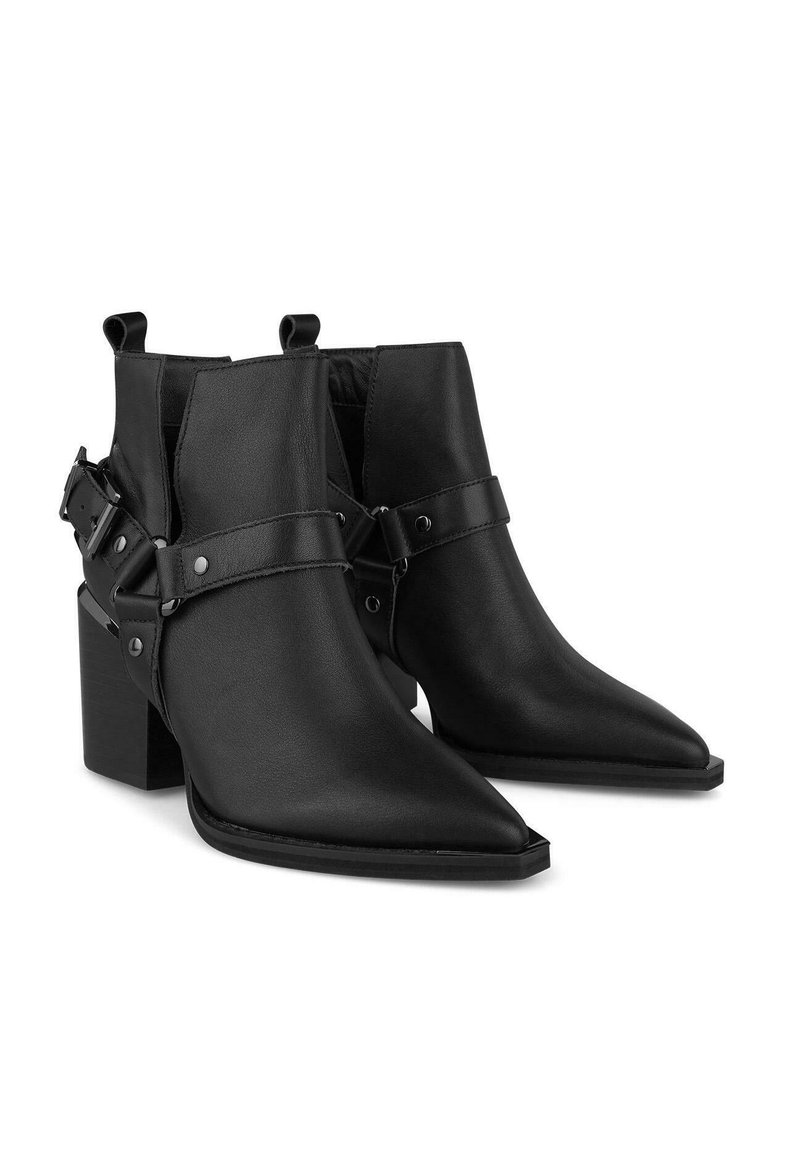 Czarne skórzane botki za kostkę mają spiczasty nos i masywny obcas. Szeroki pasek z ćwiekami zdobi kostkę, dodając szczegółu do projektu.