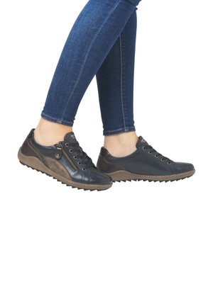 Baskets en cuir bleu marine avec des accents marron, une fermeture éclair sur le côté et une semelle en caoutchouc texturée. Conçues avec un bout arrondi et un laçage.