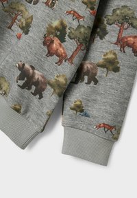 Sudadera gris con una escena del bosque que presenta ilustraciones de un oso, un bisonte y un zorro, sobre un fondo texturizado y con puños acanalados.
