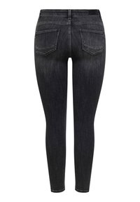 Μαύροι στενοί τζιν με ξεθωριασμένες λεπτομέρειες, πίσω τσέπες και εμφανείς ραφές, προβεβλημένοι από πίσω σε λευκό φόντο.