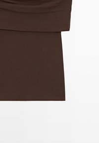 Brown fabric with a visible horizontal seam and a hemmed edge, likely part of a garment, on a white background.