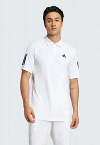 Witte polo met korte mouwen, voorzien van een kraag en zwarte drie-strepen accenten op de mouwen. Adidas-logo op de linkerkant van de borst.