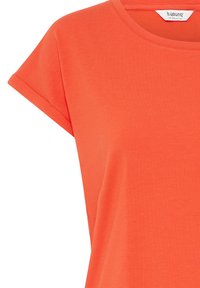 Koralfarvet t-shirt med korte ærmer, opkørte manchetter og rund halsudskæring, mærket b.young The Collection.