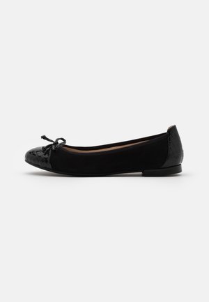 Black ballet flat with patent croc-textured toe and heel, featuring a small bow on the toe and a low flat sole.