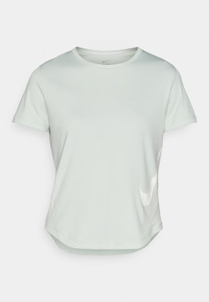 Jasnozielona, krótko nogawka koszulka sportowa z okrągłym dekoltem. Z przodu znajduje się białe logo Nike, a dolna część jest zaokrąglona. Gładka tekstura.