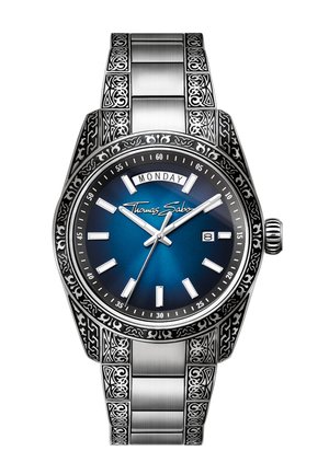 Silberne Armbanduhr mit blauem Zifferblatt, Tages- und Datumsanzeige, gravierter, gemusterter Lünette und Armband, Markenname Thomas Sabo auf dem Zifferblatt.