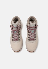 Beige tursko med en semsket finish, med rosa og grå snører, metalløse øyer og en polstret krage for komfort.
