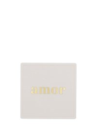 Sottobicchiere bianco quadrato con la parola "amor" impressa in lettere dorate al centro della superficie.