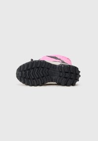 Shoe sport cu un design roz, accente negre și o talpă din cauciuc texturat, având un model de profil pronunțat pentru aderență.