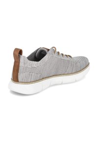 Graue Stoffsportschuhe mit strukturiertem Design, brauner Lederverstärkung an der Ferse, weißer flexibler Sohle und Schnürverschluss. Mit einem Zugband auf der Rückseite.