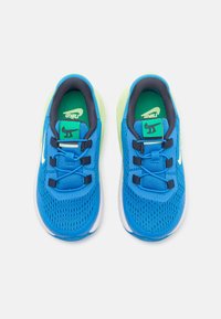 Baskets en mesh bleu avec des accents vert lime, semelle blanche et lacets noirs. Comprend une semelle intérieure verte avec un design de dessin animé.