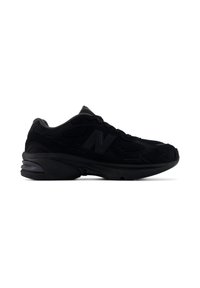 Baskets de sport noires avec détails en mesh, lacets à l’avant, semelle épaisse et un logo discret sur le côté, vues de l’extérieur.