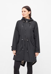 Impermeable negro con capucha, cordones ajustables, cierre frontal y bolsillos laterales. Fabricado con tejido ligero y resistente al agua.