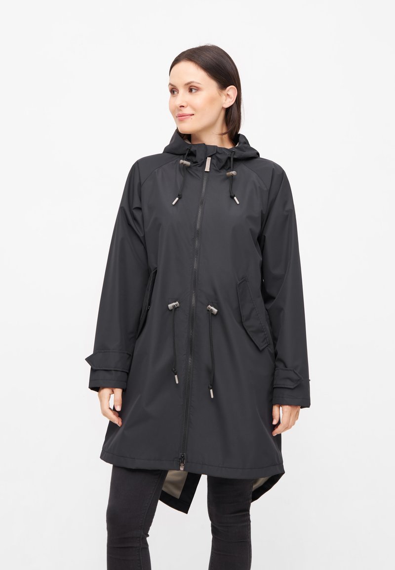 Impermeable negro con capucha, cordones ajustables, cierre frontal y bolsillos laterales. Fabricado con tejido ligero y resistente al agua.