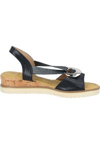 Navy leren slingback sandaal met een kurken sleehak, zilveren ringaccent en elastische banden. Heeft een gladde textuur en rubberen zool.