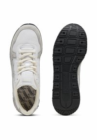White athletic shoes with mesh and suede materials, featuring a black rubber sole, round laces, and a padded collar. Notable logo inside.