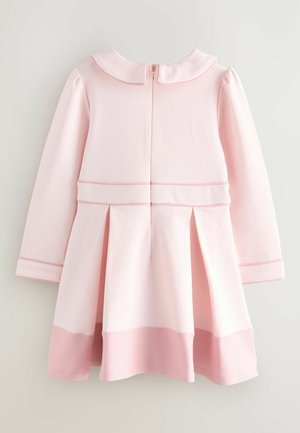 Rosa Kleid mit langen Ärmeln und einem Peter-Pan-Kragen. Besitzt Falten im Rock und einen goldenen Reißverschluss auf der Rückseite. Glattes Gewebe und kontrastierender Saum.