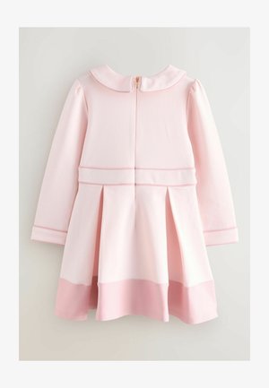 Lyserød kjole med lange ærmer og en Peter Pan-krave. Har plisseringer ved skørtet og en guld lynlås bagpå. Glat stof og kontrasterende kant.