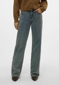 Breda jeans i ljusblå denim, med hög midja, subtila slitningar och en något urtvättad textur. Framfickor synliga.