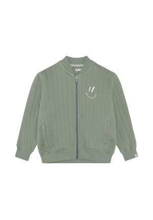 Veste matelassée verte avec une fermeture éclair, des poignets et un ourlet côtelés, portant le texte "SMILE EVERYDAY" en couleur claire sur le devant.