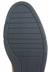 Semelle d'une chaussure avec une semelle extérieure en caoutchouc bleu foncé, présentant des motifs de grip texturés et des nervures horizontales pour la traction.