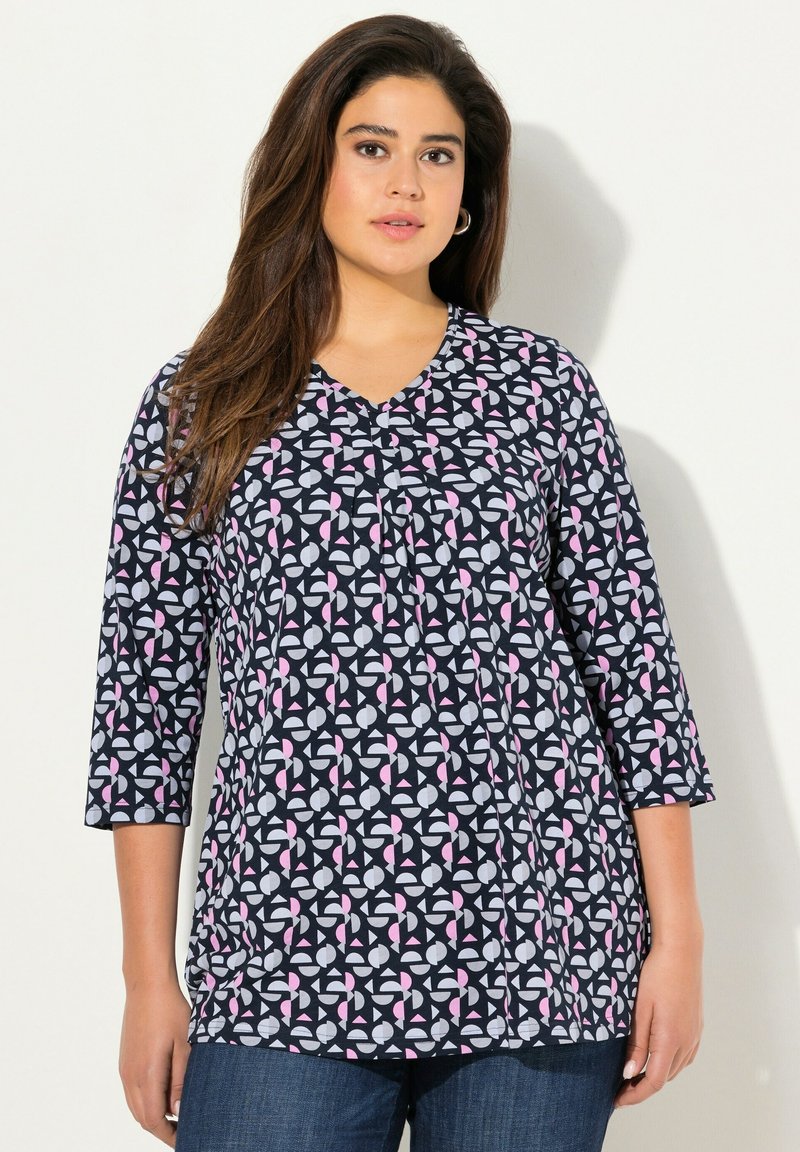 Marineblaue und weiße gemusterte Bluse mit rosa Akzenten, V-Ausschnitt, dreiviertel Ärmeln und Faltenstickerei in der Mitte.
