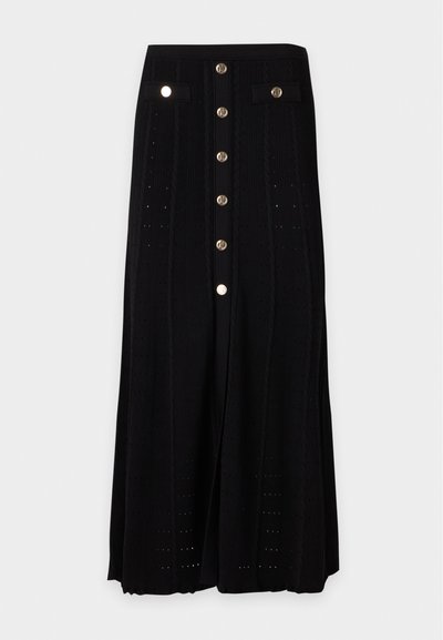 Jupe longue noire avec boutons dorés à l'avant, deux petites poches avec rabat à la taille, et un subtil motif tricoté vertical.