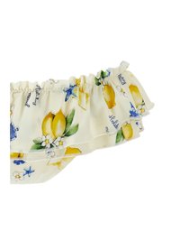 Tejido crema con escote hombro descubierto y volantes, decorado con limones amarillos, hojas verdes, flores blancas, estrellas de mar azules y patrones de texto en cursiva.