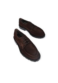 Brązowe zamszowe buty z okrągłym noskiem, pięcioma otworami na sznurówki i teksturowaną gumową podeszwą. Posiadają kontrastowe szwy i smukły design.