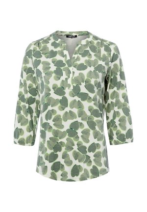 Blusa bianca con maniche 3/4, motivo astratto di foglie verdi e una piccola apertura a V sul colletto.