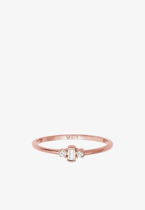 Anillo de oro rosa con una banda delgada que presenta una piedra central en corte esmeralda flanqueada por dos piedras redondas, todo en un diseño elegante.