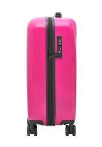 Pink hard-shell suitcase with a glossy finish, black zipper, combination lock, and four wheels for mobility. Rectangular design.
