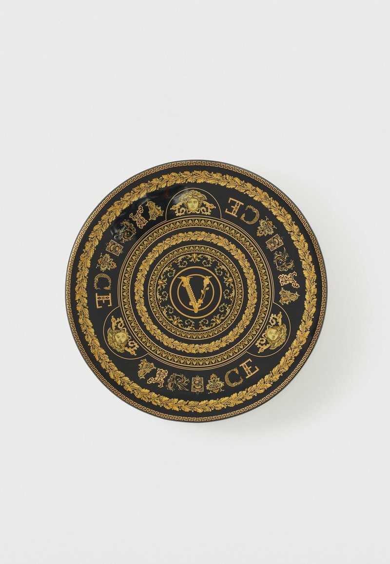 Μαύρο διακοσμητικό πιάτο με χρυσά  περίτεχνα ανθικά σχέδια, κεφάλια Μέδουσας και το κείμενο "Versace" που περιστρέφεται γύρω από ένα κεντρικό στιλιζαρισμένο έμβλημα "V".
