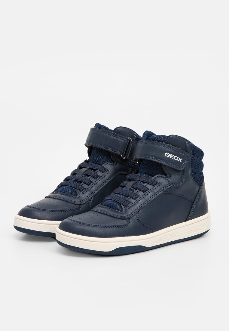 Mörkblå läderhög-top sneakers med vita gummisulor, kontrasterande snören och ett kardborreband. Har subtil logotypdetaljering på sidan.