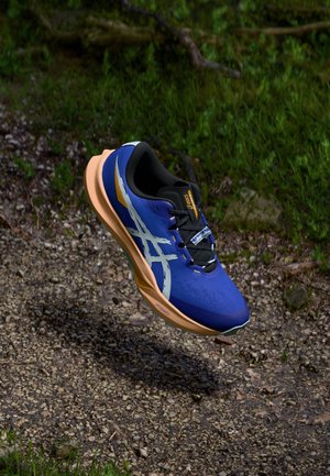 Scarpa da running con tomaia blu e dettagli bianchi, interno nero e suola arancione. Design leggero con superficie texturizzata.